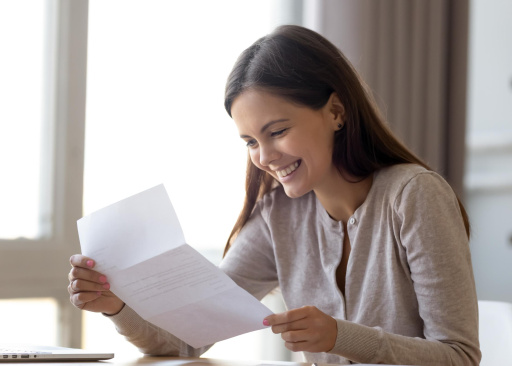 Rapariga sorridente a ler a partir de uma folha de papel